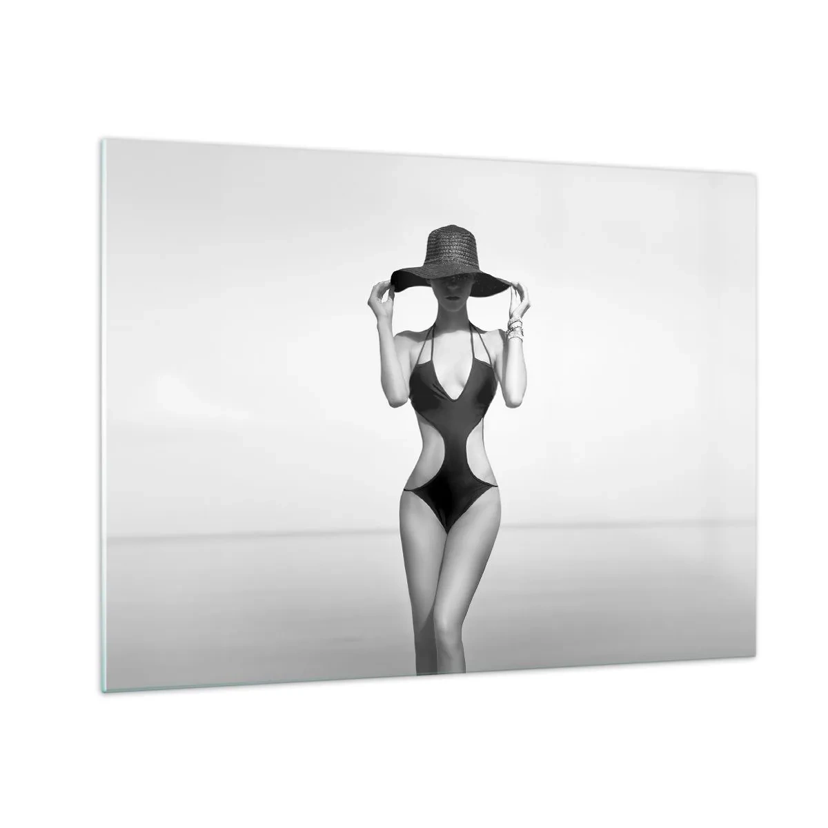 Glastavla - Bild på glas - En kvinna i svart baddräkt och hatt mot havet - 70x50cm - Mitt förnamn är: Elegans - Modern väggdekoration för vardagsrum och sovrum ARTTOR
