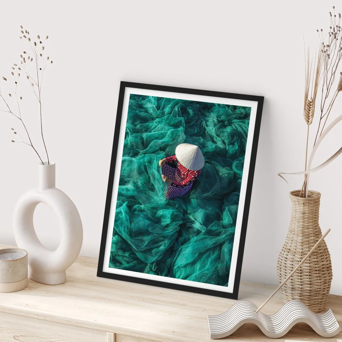 Affisch i svart ram - En person som bär hatt bland gröna fisknät - 50x70cm - I nätens hav - Modern väggdekoration för vardagsrum och sovrum ARTTOR