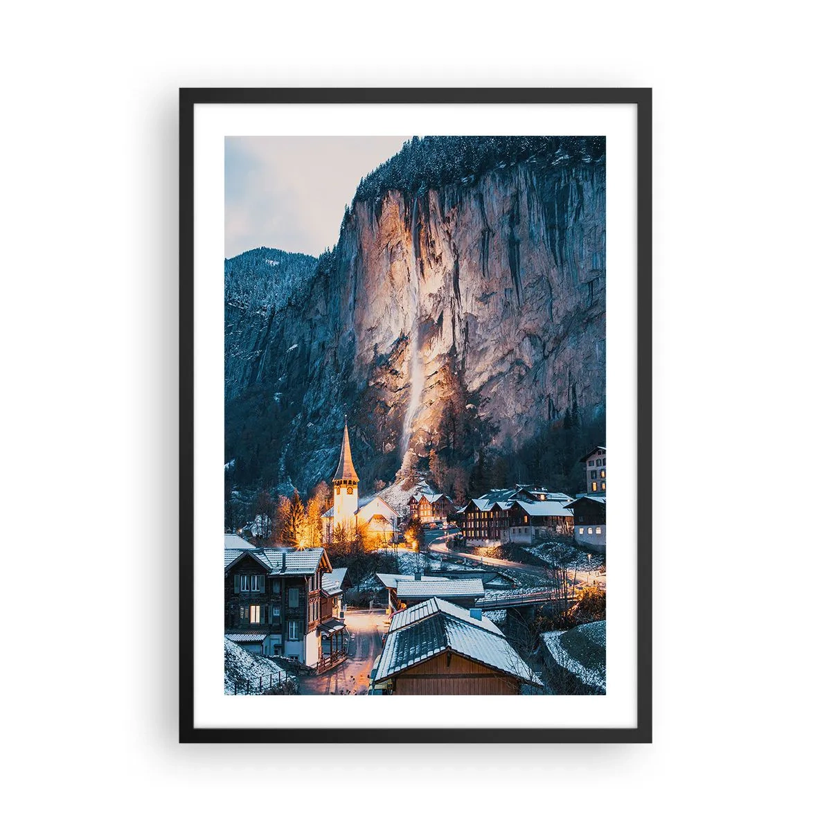 Affisch i svart ram - Upplyst vinterby vid foten av klippan - 50x70cm - Vinterns ljusa ande - Modern väggdekoration för vardagsrum och sovrum ARTTOR