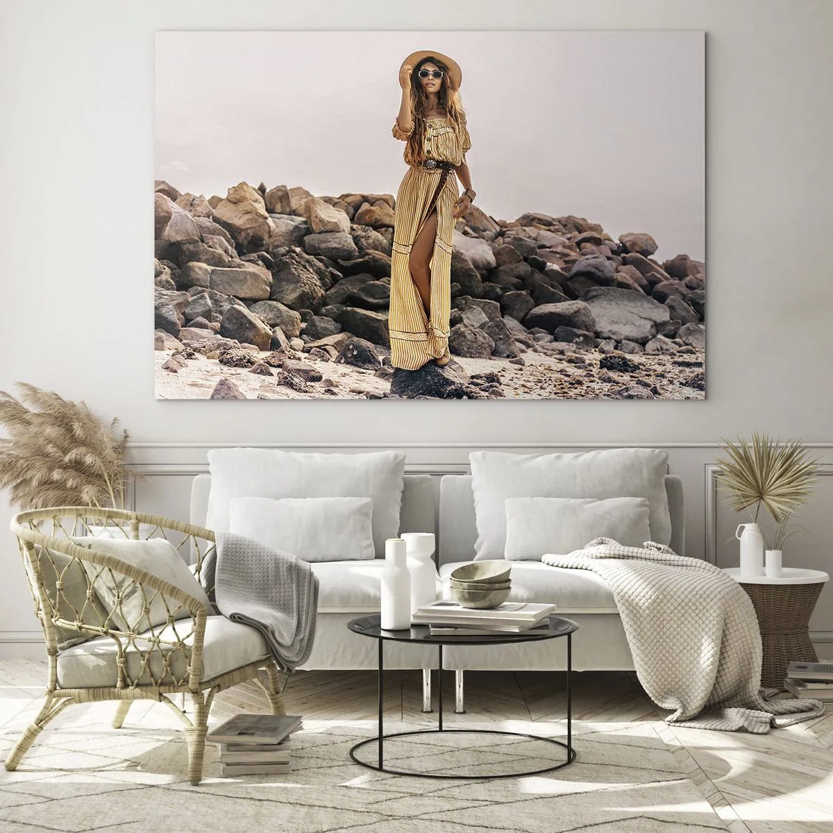 Glastavla - Bild på glas - En kvinna i boho-stilklänning mot en klippig strand - 70x50cm - Stenarnas magi - Modern väggdekoration för vardagsrum och sovrum ARTTOR
