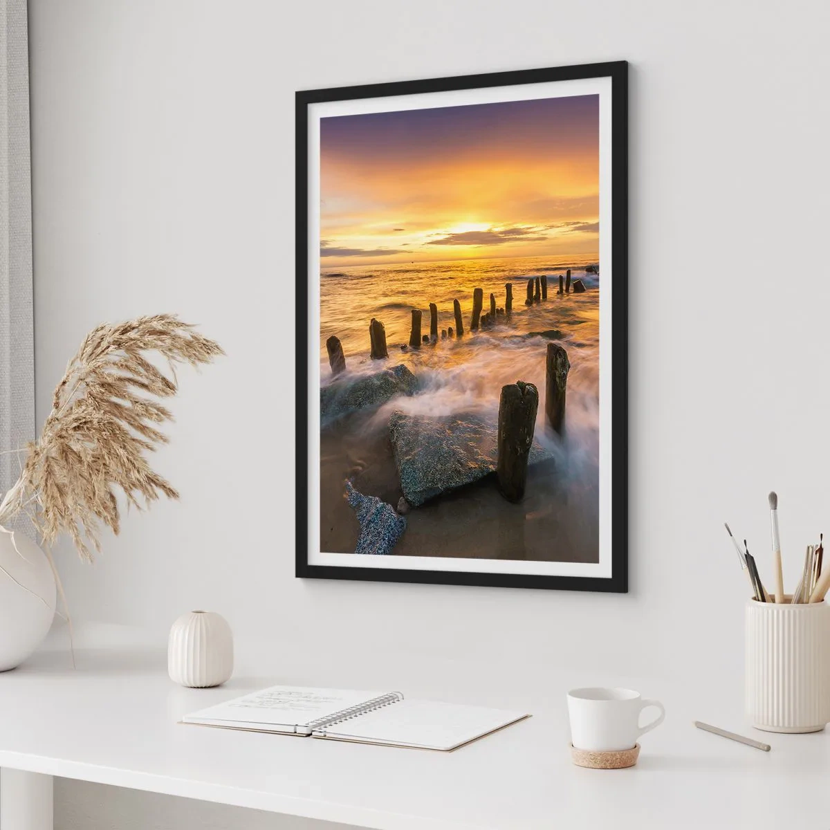 Affisch i svart ram - Solnedgång över havet med trästolpar på stranden - 50x70cm - Östersjöns råa skönhet - Modern väggdekoration för vardagsrum och sovrum ARTTOR