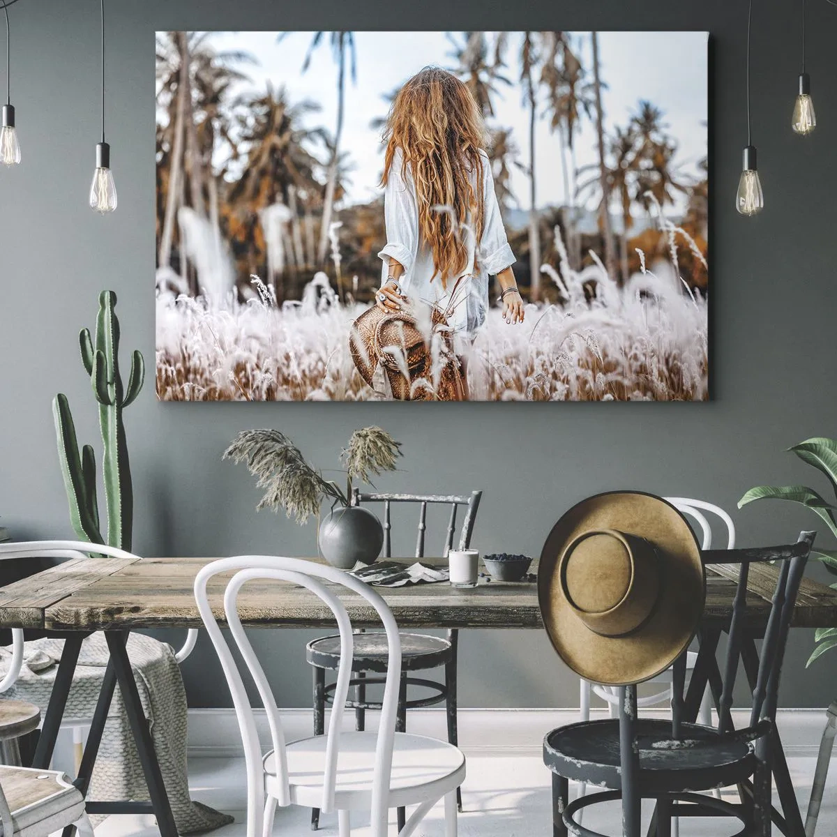 Canvastavla - Bild på duk - En kvinna i ett gräsfält med palmer i bakgrunden vid solnedgången - 70x50cm - Född ur gräsdun - Modern väggdekoration för vardagsrum och sovrum ARTTOR