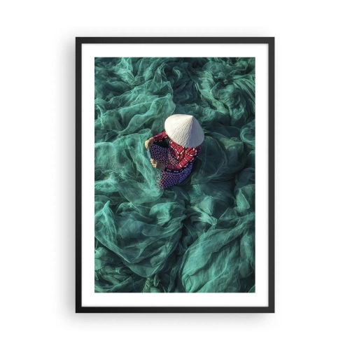Affisch i svart ram - En person som bär hatt bland gröna fisknät - 50x70cm - I nätens hav - Modern väggdekoration för vardagsrum och sovrum ARTTOR