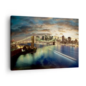 Canvastavla - Bild på duk - En upplyst bro med staden i bakgrunden, med ljus som reflekteras i vattnet. - 70x50cm - En ljus kväll över Manhattan. - Modern väggdekoration för vardagsrum och sovrum ARTTOR