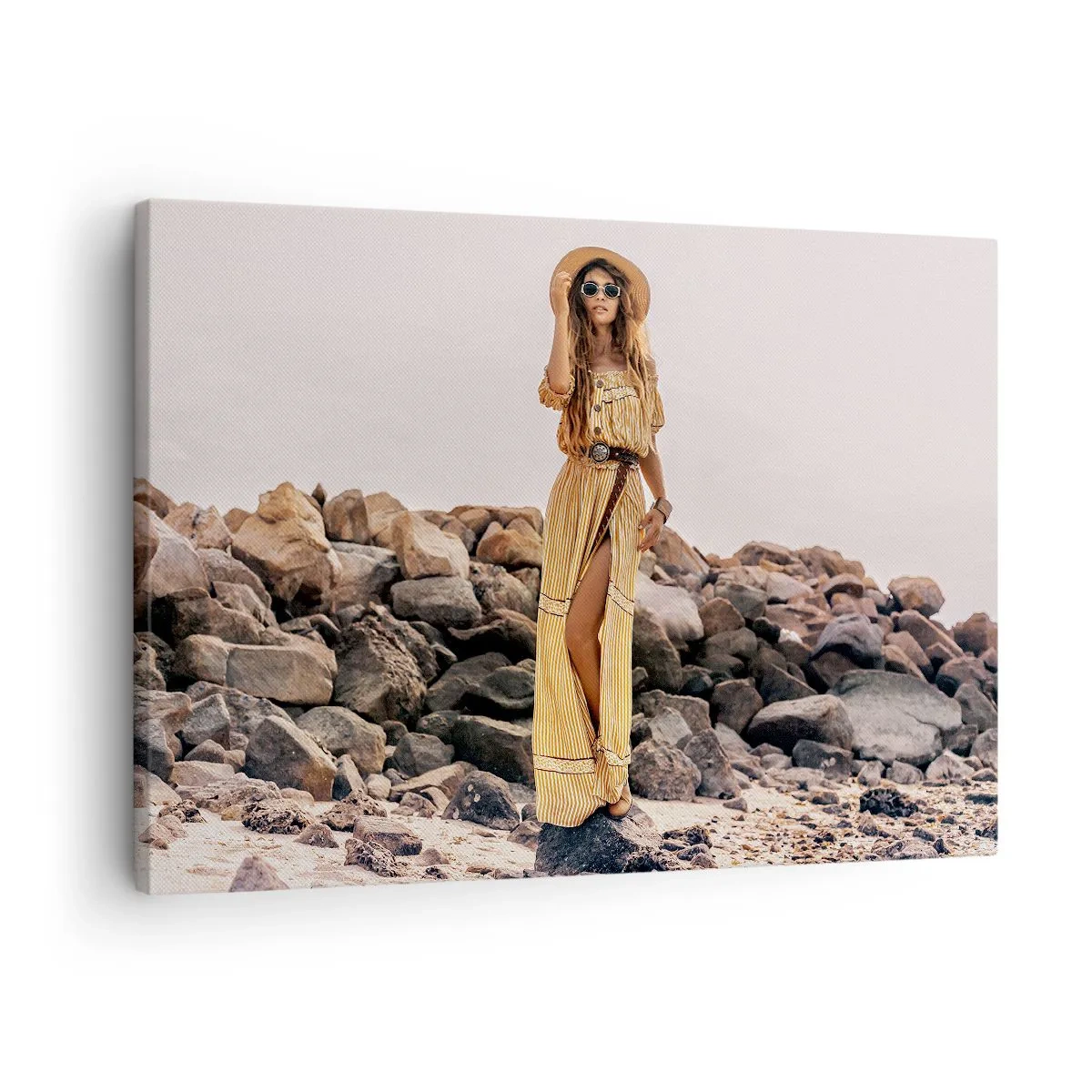 Canvastavla - Bild på duk - En kvinna i boho-stil mot en stenig strandbakgrund - 70x50cm - Stenarnas magi - Modern väggdekoration för vardagsrum och sovrum ARTTOR