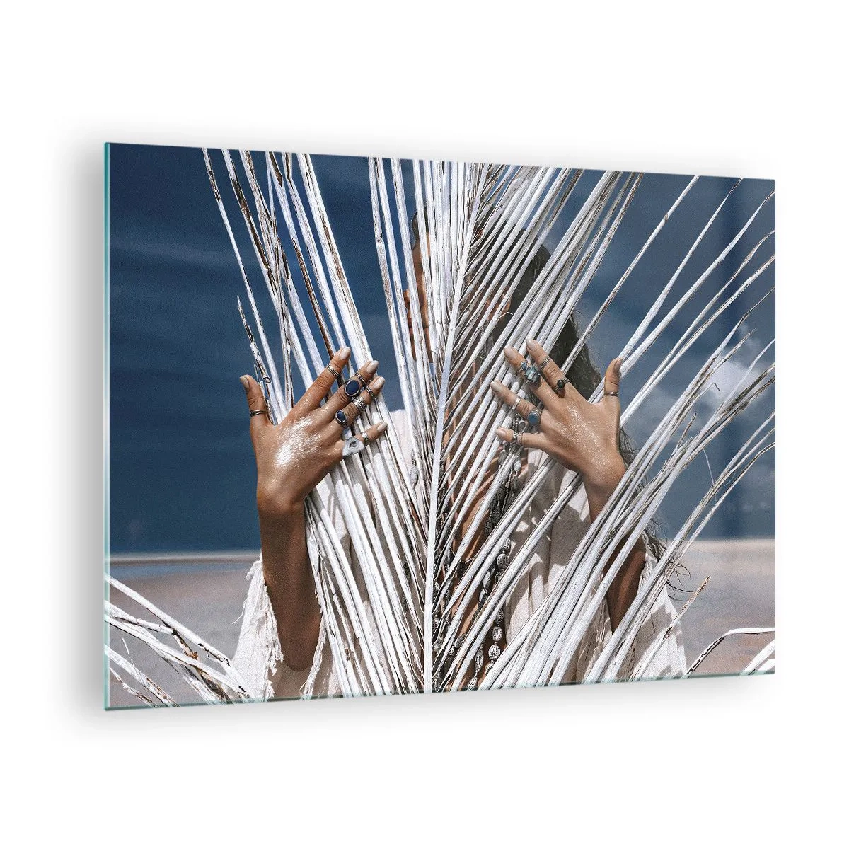 Glastavla - Bild på glas - En kvinnas händer dekorerade med ringar bakom en torr palmträd - 70x50cm - Schamanens flickvän? - Modern väggdekoration för vardagsrum och sovrum ARTTOR