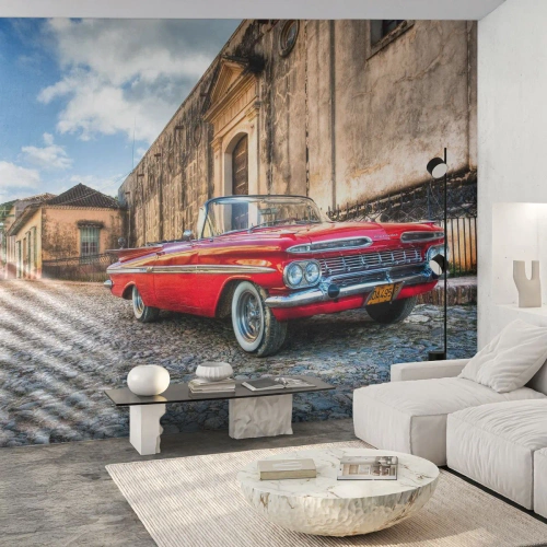 Fototapet Standard Eco - Röd klassisk cabriolet på en kullerstensgata - 100x70cm - Kubansk stämning - Modern väggdekoration för vardagsrum och sovrum ARTTOR