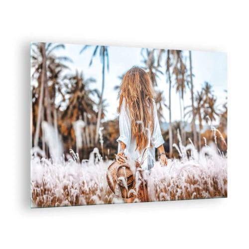 Glastavla - Bild på glas - En kvinna i gräset med en hatt i handen mot en bakgrund av palmer - 70x50cm - Född ur gräsdun - Modern väggdekoration för vardagsrum och sovrum ARTTOR