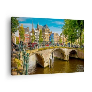 Canvastavla - Bild på duk - En pittoresk kanal med en bro i Amsterdam - 70x50cm - Vår vid kanalen - Modern väggdekoration för vardagsrum och sovrum ARTTOR