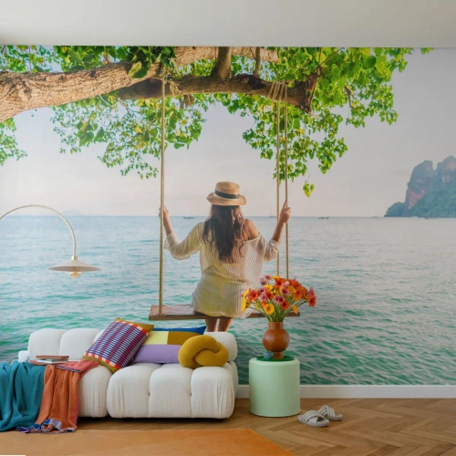 Fototapet Standard Eco - En kvinna på en gunga som svävar över havsvattnet - 100x70cm - Livet är vackert - Modern väggdekoration för vardagsrum och sovrum ARTTOR