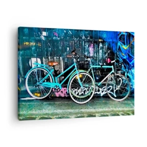 Canvastavla - Bild på duk - Två turkosa cyklar mot en urban graffitibakgrund. - 70x50cm - Oxens stad - Modern väggdekoration för vardagsrum och sovrum ARTTOR