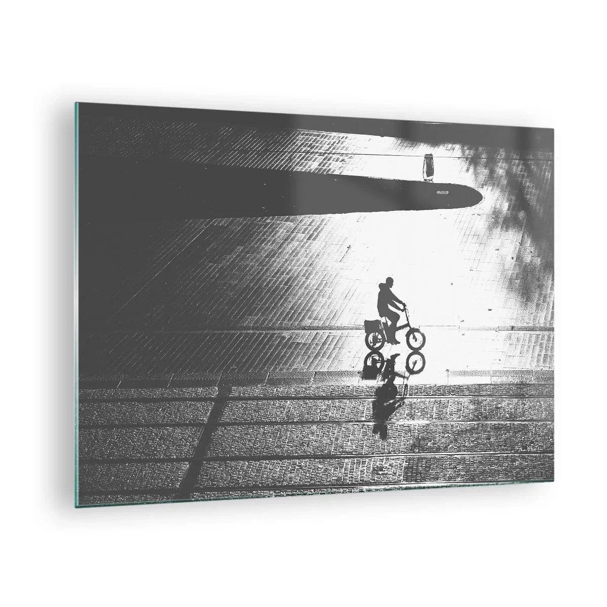 Glastavla - Bild på glas - Man cyklar genom staden, reflektion i vattnet, svartvit bild - 70x50cm - Rakt fram genom staden - Modern väggdekoration för vardagsrum och sovrum ARTTOR