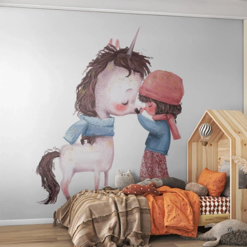 Fototapet Standard Eco - En flicka och en enhörning i varma kläder i en sagoillustration - 100x70cm - Vintersaga - Modern väggdekoration för vardagsrum och sovrum ARTTOR